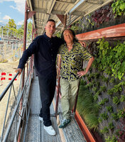 Patrick Blanc and Bob Morard on the scaffolding for plant installation of the Vertical Garden of the new Oiken electric substation ith the old one in the background, Sion, Switzerland, June 2026