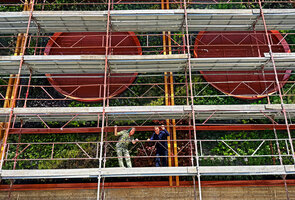 Patrick Blanc and the architect Bob Morard on the scaffolding at the end of plant installation of the Vertical Garden covering the four faces of the new Oiken electric substation, Sion, Switzerland, June 2026