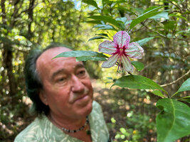 Patrick Blanc behind the large purple veined flower of Clerodendrum arenarium, Ankin&#039;ny Nofy Reserve, Madagascar, Aug. 2024