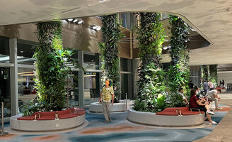 Patrick Blanc checking the plant growth on the columns at the Arrrival level, Changi airport, Terminal 2, Singapore, July 2022
