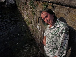 Patrick Blanc in front of a stone wall covered by the naturalized mexican Erigeron karvinskianus , Como lake, Italy, June 2015