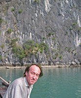 Patrick Blanc in front of a vertical karst tower partly covered by Cycas tropophylla, Halong Bay, Vietnam, Jan. 2007