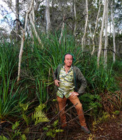 Patrick Blanc in front of the tufted sedge Gahnia novocaledonensis with tall black inflorescences, Riviere Bleue, New Caledonia, Aug. 2023