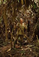 Patrick Blanc in muddy varzea forest looking at dead Heliconia leaves, Iquitos, Peru, Aug 2014