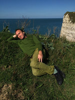 Patrick Blanc laying above sea cliff, among Brassica oleracea, Etretat, Normandy, France, Sept. 2015