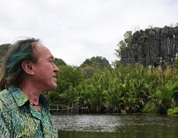 Patrick Blanc looking at the mangrove palm Nypa fruticans and Dracaena multiflora at the top of karst boulder, Rammang Rammang, Maros, South Sulawesi,June 2019