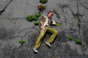 Patrick Blanc lying among plants growing in the tarmac cracks, Shikoku, Japan, Aug 2008