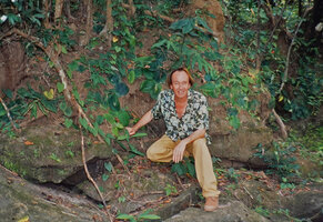 Patrick Blanc sitting at the base of a stone bank covered by a Kaempferia with appressed leaves, Beng Melea area, Cambodia, May 2004