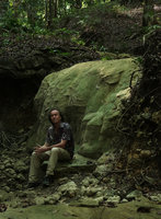 Patrick Blanc sitting on a dry travertine riverbed encrusted by green algae, Pacitan, Java, May 2018