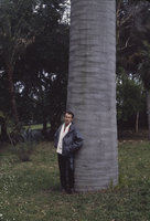 Patrick Blanc standing at the base of the huge Jubaea chilensis, Villa Thuret, Antibes, France, 1982