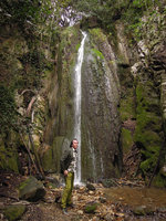 Patrick Blanc under a petrifying waterfall with travertine covered by algae and mosses, Eze Village, Alpes Maritimes, France, April 2014