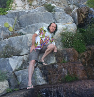 Patrick Blanc close to an artificial waterfall with Erigeron karvinskianus colonising the seeping rocks, Botanical Garden, Eze Village, Alpes Maritimes, France, Aug. 2015